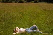 Молодая женщина отдыхает в поле — стоковое фото