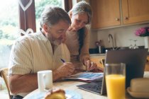 Seniorenpaar prüft Rechnung zu Hause — Stockfoto