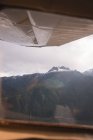 Крупный план крыла самолета против горы — стоковое фото