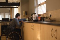 Disabled man preparing coffee in kitchen at home — Stock Photo
