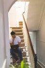 Junger Mann benutzt Laptop im Treppenhaus — Stockfoto