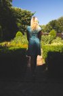 Visão traseira da mulher de pé no jardim — Fotografia de Stock