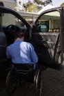 Visão traseira do homem com deficiência em cadeira de rodas perto do carro — Fotografia de Stock