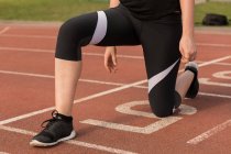 Low section of female athletic exercising on running track — Stock Photo