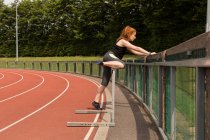 Junge Sportlerin übt auf Geländer an Sportanlage — Stockfoto