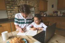 Отец помогает дочери в учебе на дому — стоковое фото