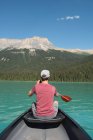 Visão traseira do homem de barco no rio nas montanhas — Fotografia de Stock