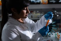 Female scientist examining test tube in laboratory — Stock Photo