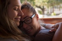 Primer plano de pareja lesbiana abrazándose en casa - foto de stock