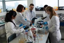 Équipe de scientifiques expérimentant ensemble en laboratoire — Photo de stock