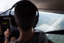 Avión piloto de visión trasera sobrevolando montañas y paisajes - foto de stock