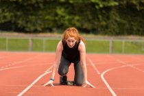 Young female athlete ready to run on running track — Stock Photo