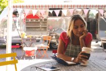 Молода жіноча офіціантка має каву у відкритому кафе — стокове фото
