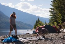 Couple installant une tente près de la rivière dans les montagnes — Photo de stock