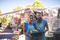 Paar blickt in der Nähe von Food-Truck in die Kamera — Stockfoto