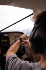 Piloto que utiliza smartwatch durante o voo no cockpit da aeronave — Fotografia de Stock