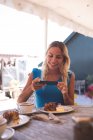 Красива жінка знімає з мобільного телефону у відкритому кафе — стокове фото