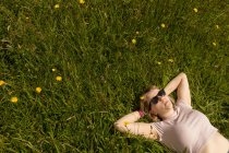 Молода жінка розслабляється в полі — стокове фото