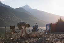 Mann bereitet sich auf Lagerfeuer in den Bergen vor — Stockfoto