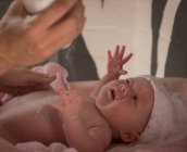 Close-up de mãe aplicando talco em pó para seu bebê após o banho — Fotografia de Stock