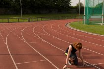 Junge Athletin bereit für den Lauf auf Laufstrecke — Stockfoto