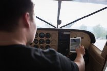 Rückansicht des Piloten mit digitalem Tablet im Cockpit — Stockfoto