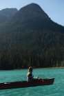 Mujer remando un bote en el río en las montañas - foto de stock