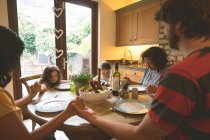 Семья молится перед едой на дому — стоковое фото