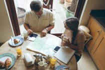 High angle view of senior couple discussing over a map at home — Stock Photo