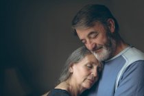Романтическая старшая пара обнимает друг друга дома — стоковое фото