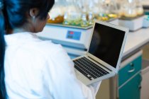 Женщина-ученый использует ноутбук в лаборатории — стоковое фото