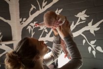 Mother playing with baby in bedroom at home — Stock Photo