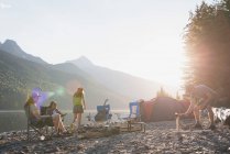 Groupe d'amis camper près de la rivière par une journée ensoleillée — Photo de stock