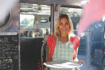 Красива жіноча офіціантка стоїть в продовольчій вантажівці — стокове фото