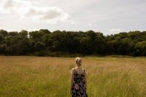 Thoughtful woman standing in the field — Stock Photo