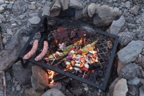 Food heating on a barbecue at campsite — Stock Photo