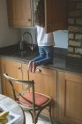 Vista trasera de la chica en busca de comida en la cocina en casa - foto de stock