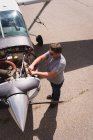Vista ad alto angolo di ingegnere manutenzione motore aereo vicino hangar — Foto stock