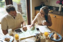 Senior couple discussing over a map at home — Stock Photo