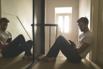 Man using mobile phone near stairs at home — Stock Photo