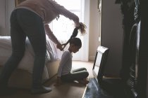 Mãe está fazendo um penteado para sua filha em casa — Fotografia de Stock