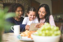 Famille heureuse en utilisant une tablette numérique à la maison — Photo de stock