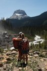 Casal de pé em uma montanha nas montanhas — Fotografia de Stock