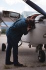 Ingénieur entretien moteur d'avion près du hangar par une journée ensoleillée — Photo de stock