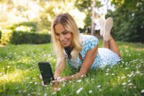 Femme prenant selfie avec téléphone portable dans le parc — Photo de stock