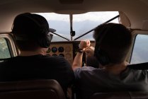 Piloto que utiliza smartwatch durante o voo no cockpit da aeronave — Fotografia de Stock