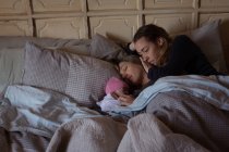 Couple lesbien avec bébé relaxant sur le lit à la maison — Photo de stock