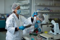 Cientistas experimentando juntos em laboratório — Fotografia de Stock