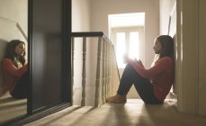 Frau benutzte Handy in der Nähe von Treppen zu Hause — Stockfoto