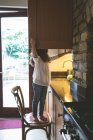 Девочка ищет еду на кухне дома — стоковое фото